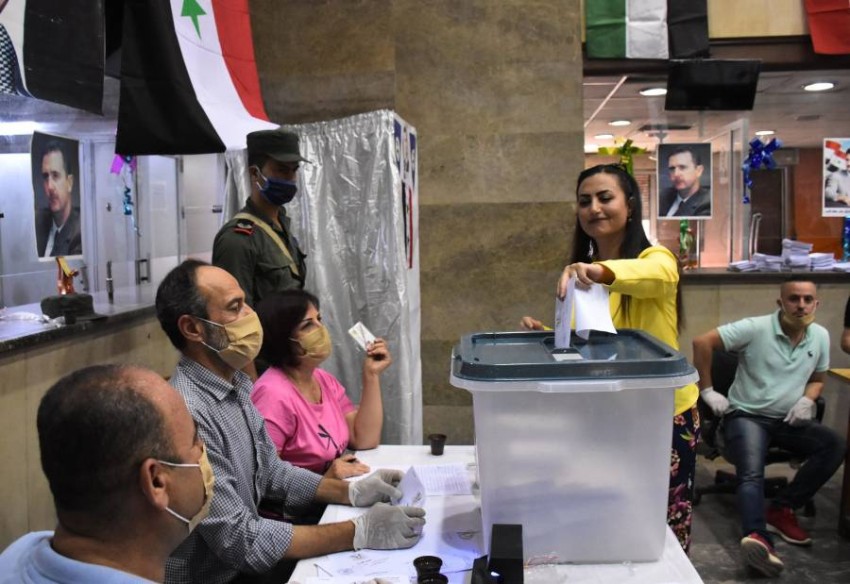 A woman casts her ballot at a voting station in the northern Syrian city of Aleppo on July 19, 2020, during the parliamentary elections. - Syrians vote today to elect a new parliament as the Damascus government grapples with international sanctions and a crumbling economy after retaking large parts of the war-torn country. (Photo by - / AFP)