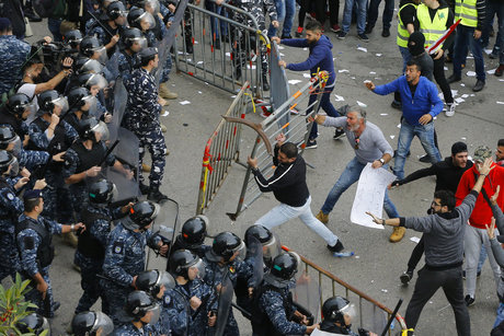 Lebanese anti-government protesters clash with riot policemen as they try to reach the government building in central Beirut, Lebanon, Sunday, Dec. 23, 2018. Hundreds of Lebanese protested against deteriorating economic conditions as politicians are deadlocked over forming a new government. (AP Photo/Bilal Hussein)